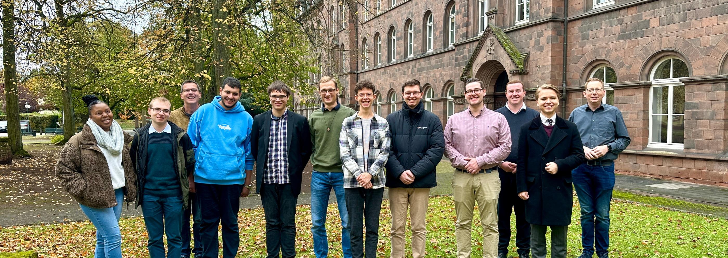 Menschen stehen vor dem Felixianum auf einer Wiese
