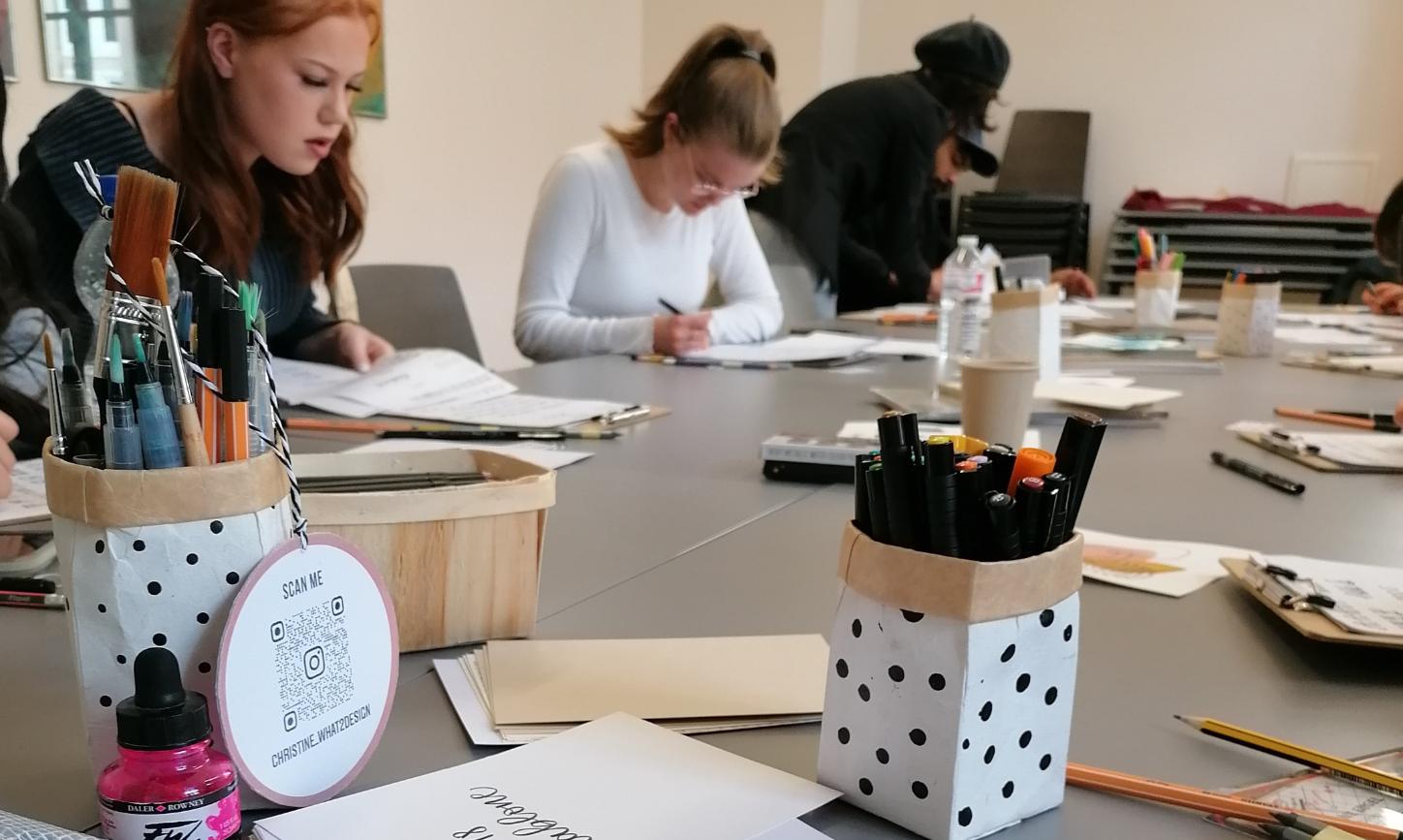 Menschen sitzen an einem Tisch und schreiben