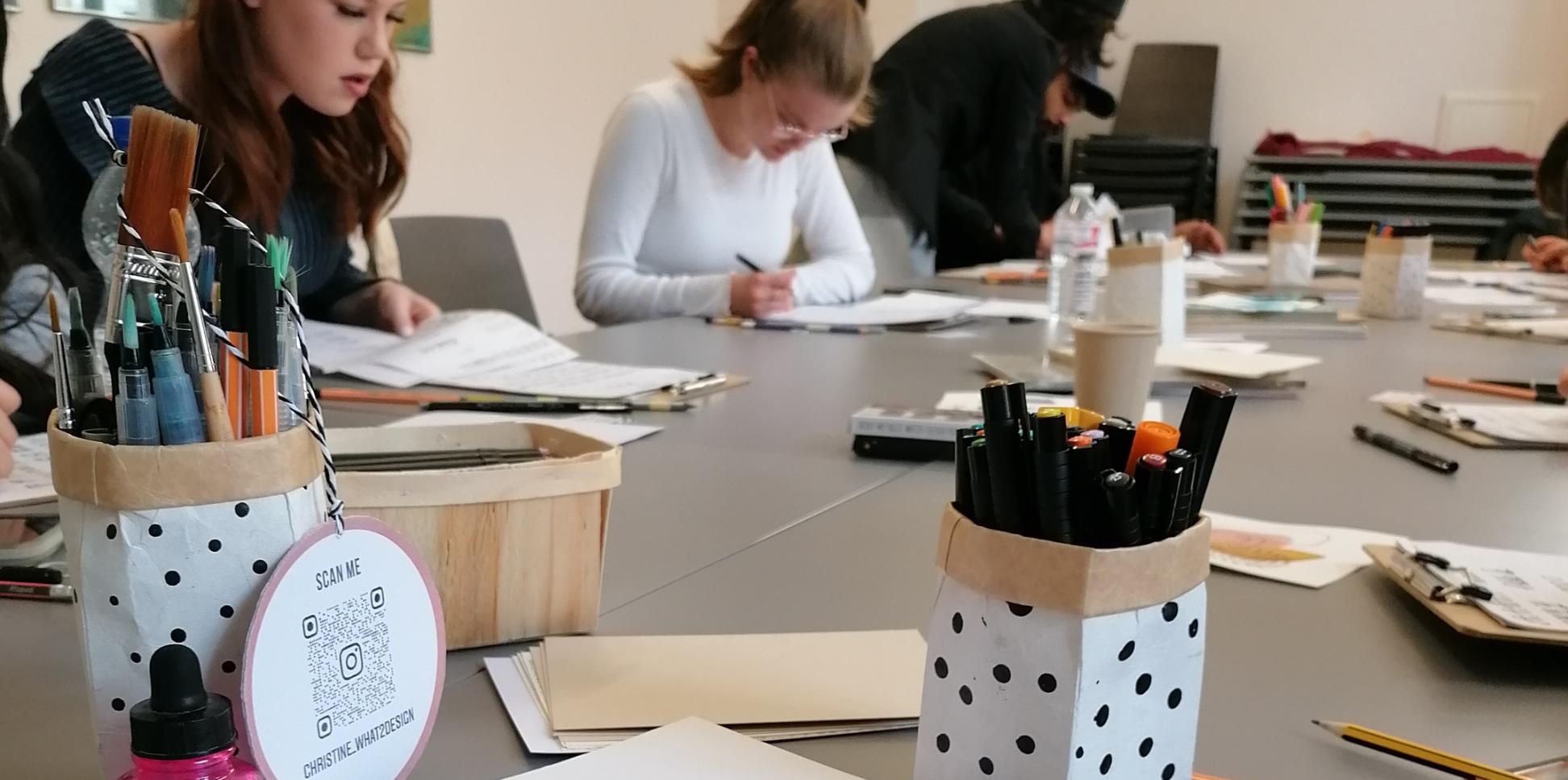Menschen sitzen an einem Tisch und schreiben