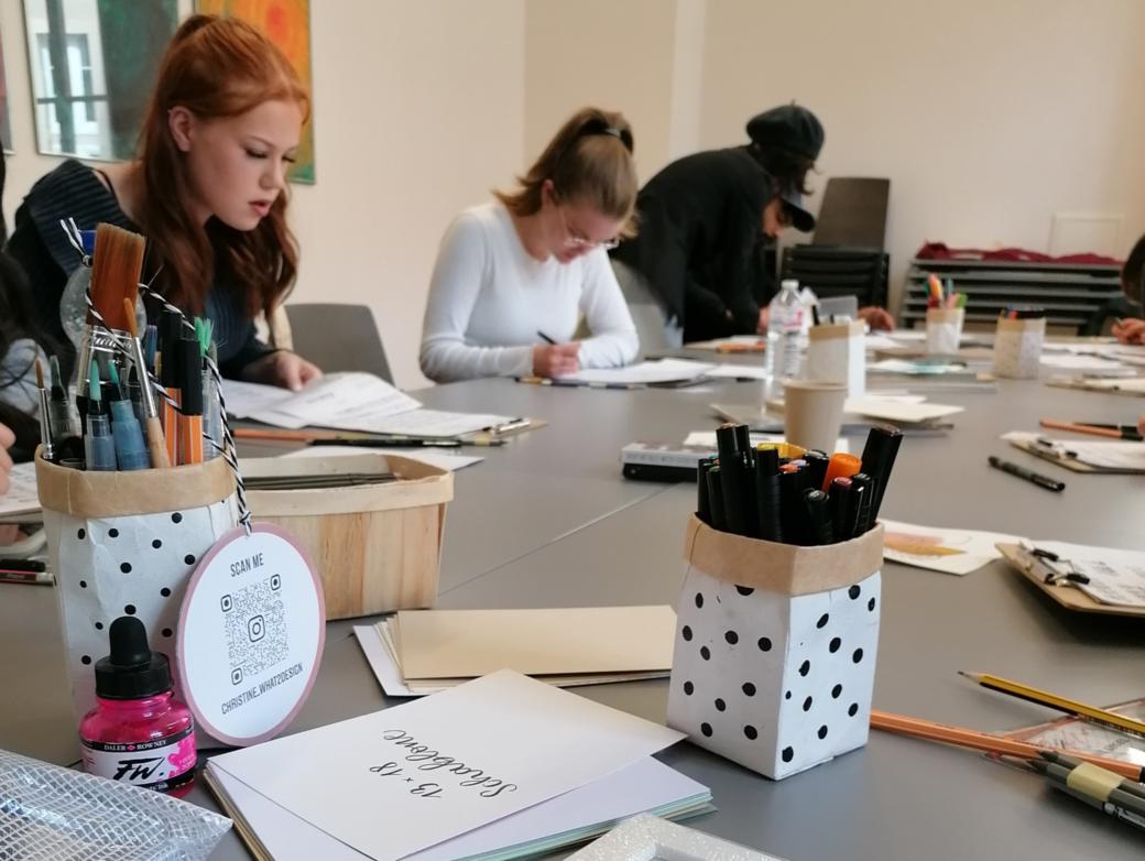 Menschen sitzen an einem Tisch und schreiben